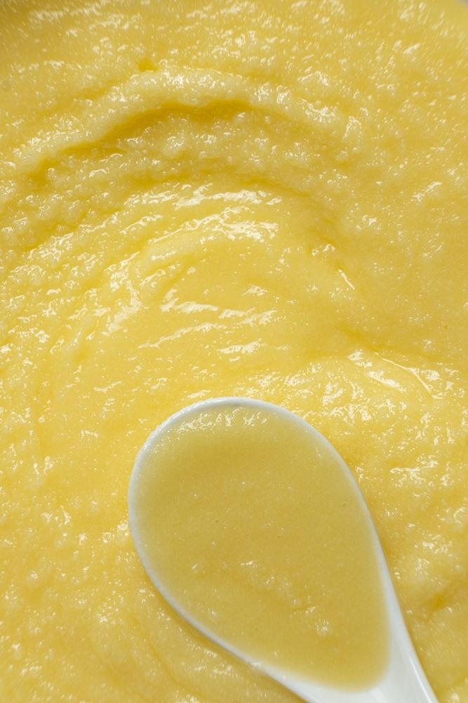 Natural grainy texture of slow-cooked ghee on a spoon